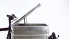 Closeup of the open lid of an aluminium box seen from the side, mounted on the cargo bed of a Bullitt cargo bike