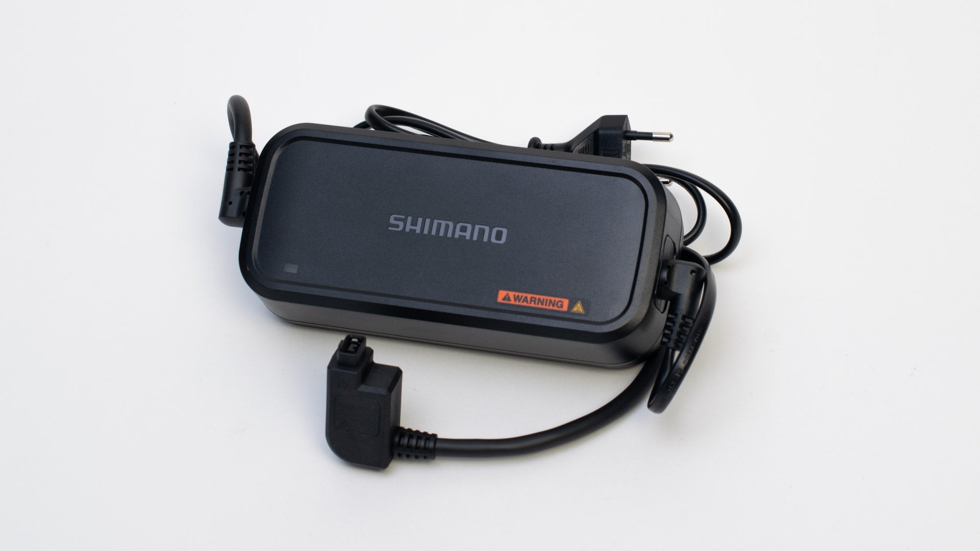 Shimano e-bike battery charger on white background. The charger has a C-type plug.