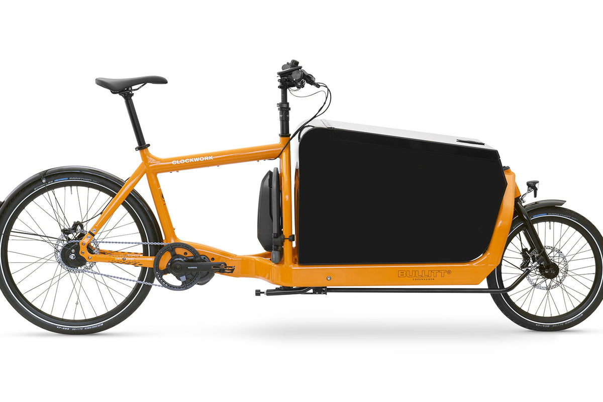 An eBullitt 6100 in the Clockwork (orange) colourway, with a black Convoy alumninium cargo box mounted on the cargo bed.