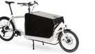 A white eBullitt cargo bike with a lidded black aluminium cargo box mounted on the cargo bed