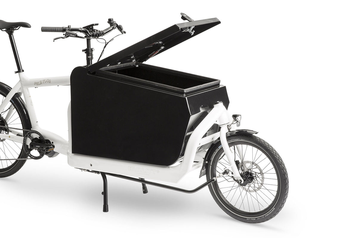 A white eBullitt cargo bike with a lidded black aluminium cargo box mounted on the cargo bed. The lid is open, with a hydraulic arm and the locking mechanism visible.