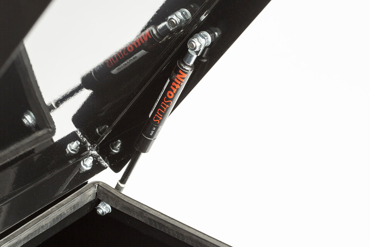 Closeup of the hydraulic arm holding the open lid on the convoy cargo box