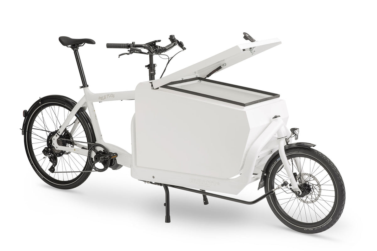 A white eBullitt cargo bike with a lidded white aluminium cargo box mounted on the cargo bed. The lid is open, with a hydraulic arm and the locking mechanism visible.