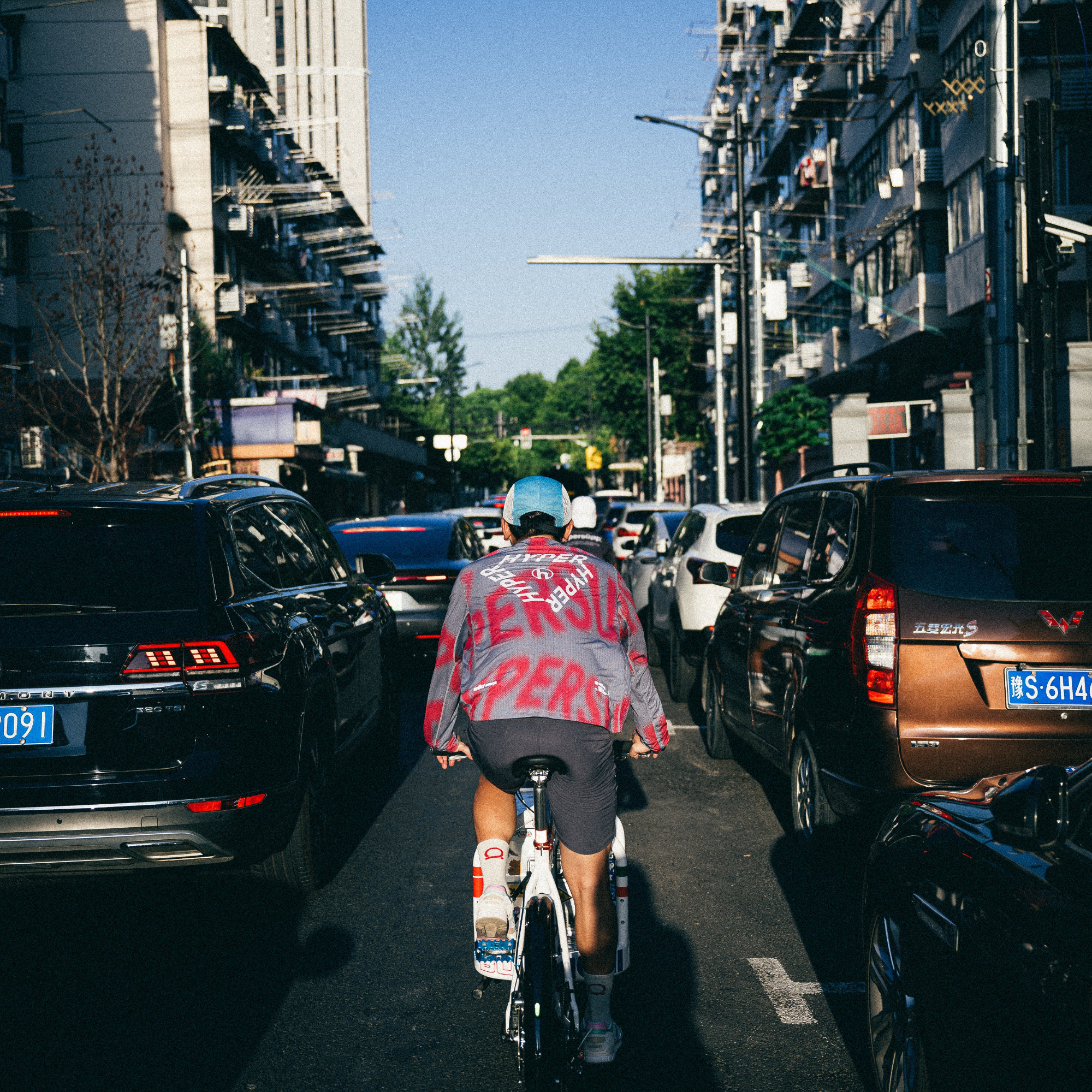 a guy on a Bullitt cargo bike, seen from behind, riding in a congested city street.