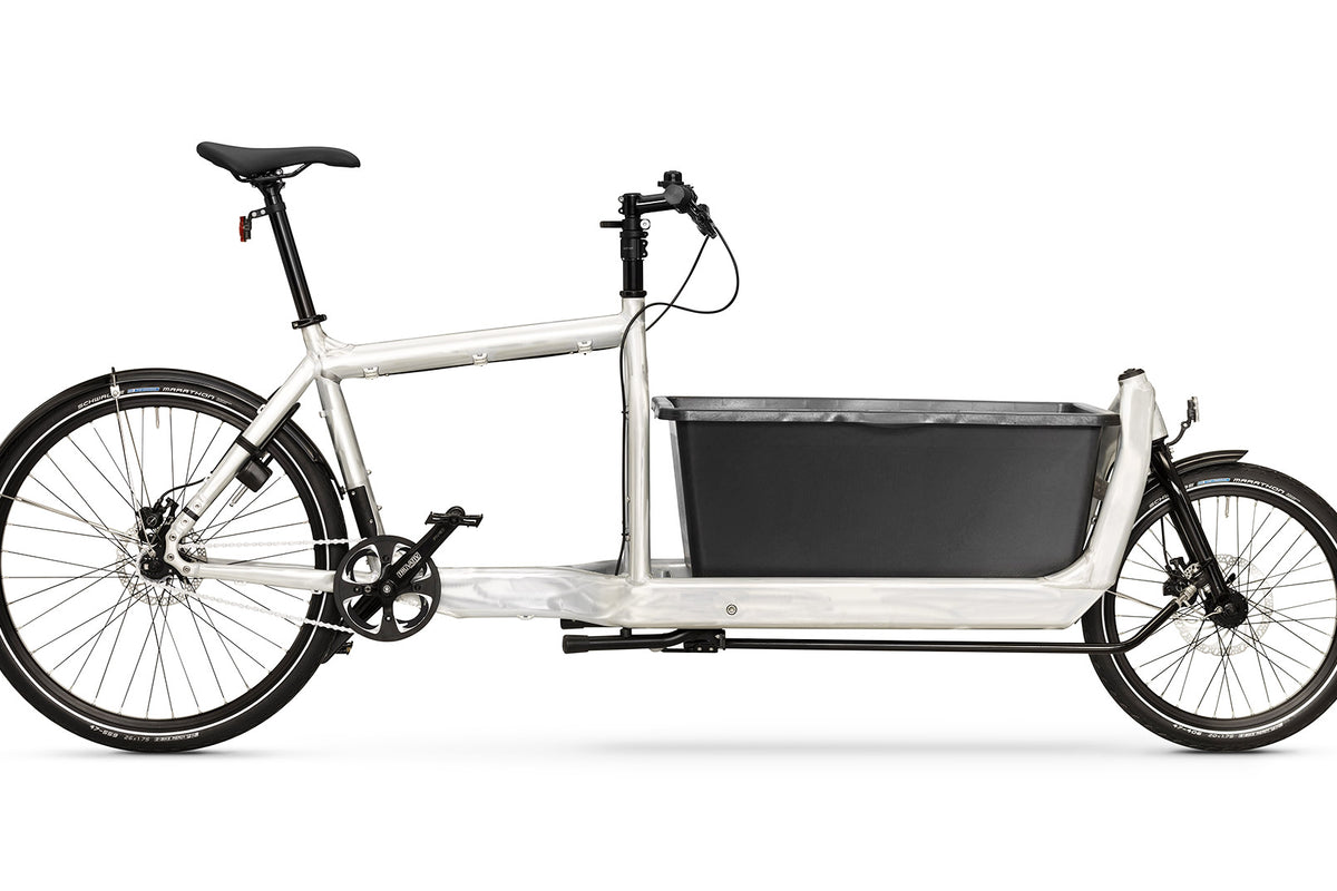An Original Bullitt cargo bike in Raw aluminium colourway with a mortar tub style black plastic box on the cargo bed