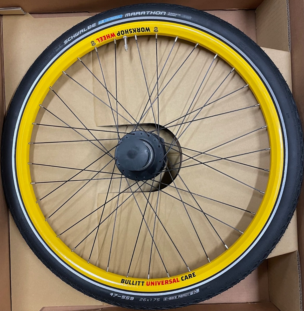 A service wheel with yellow rim lying in a cardboard box