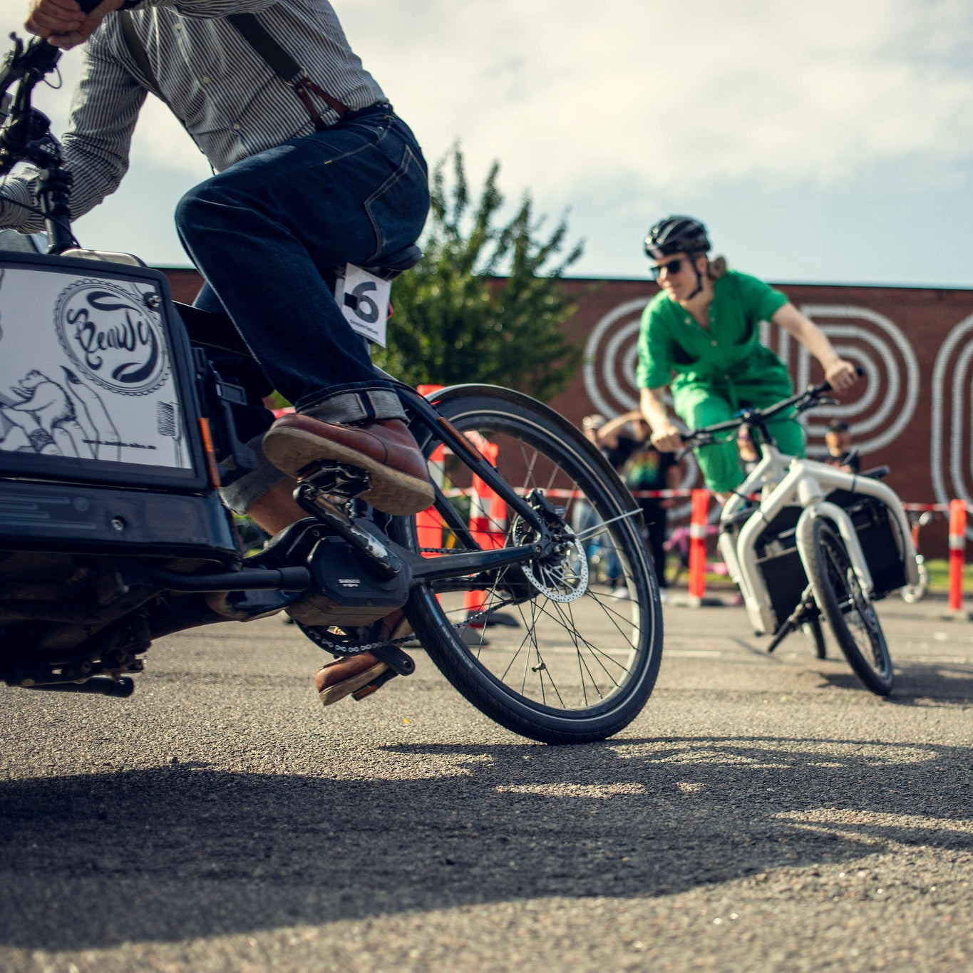Two people in a race on Bullitts, turning a sharp corner.