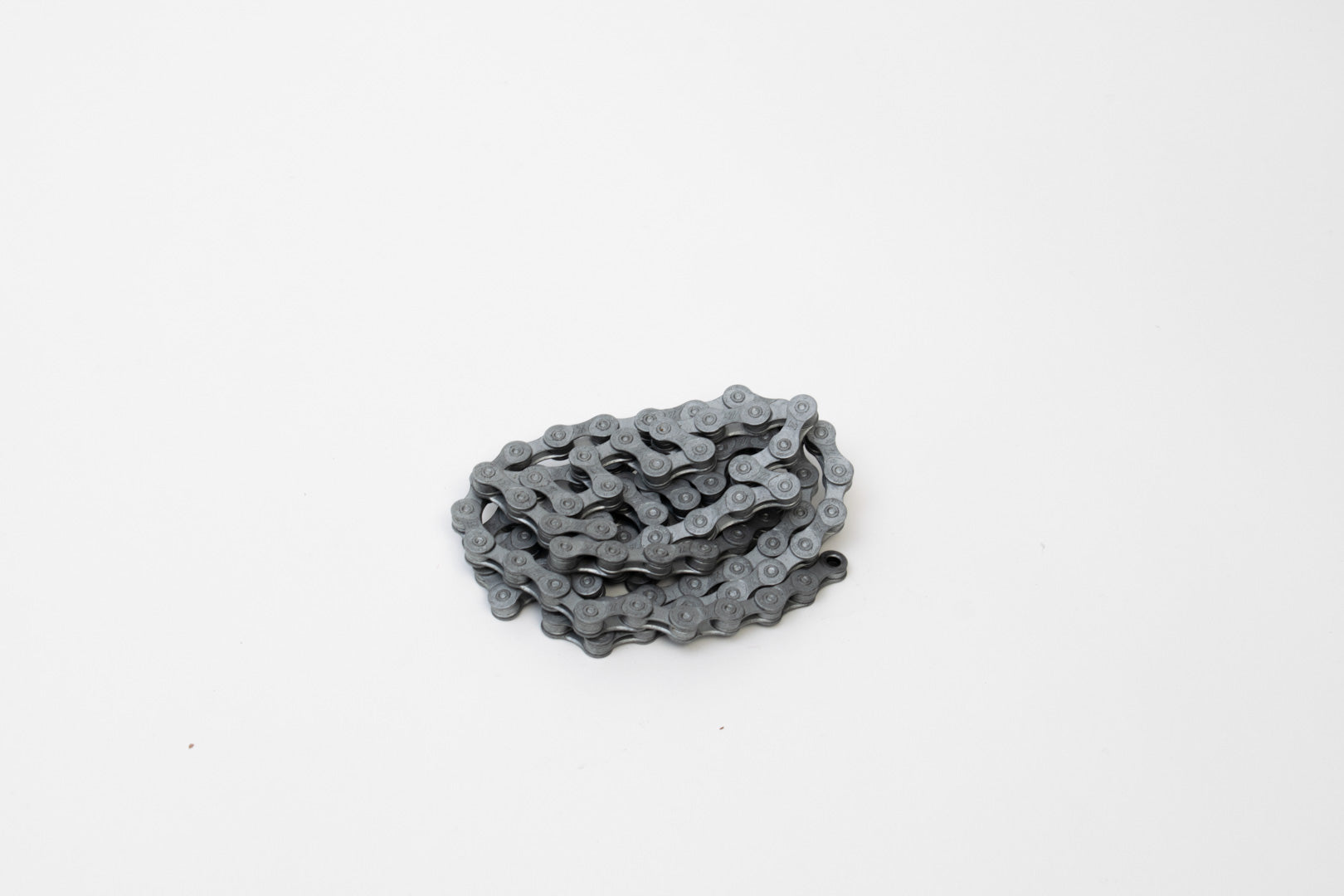 Bike chain coiled up on a white surface
