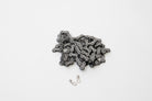 Shimano bike chain coiled up on a white surface with a Shimano quick link lying beside it