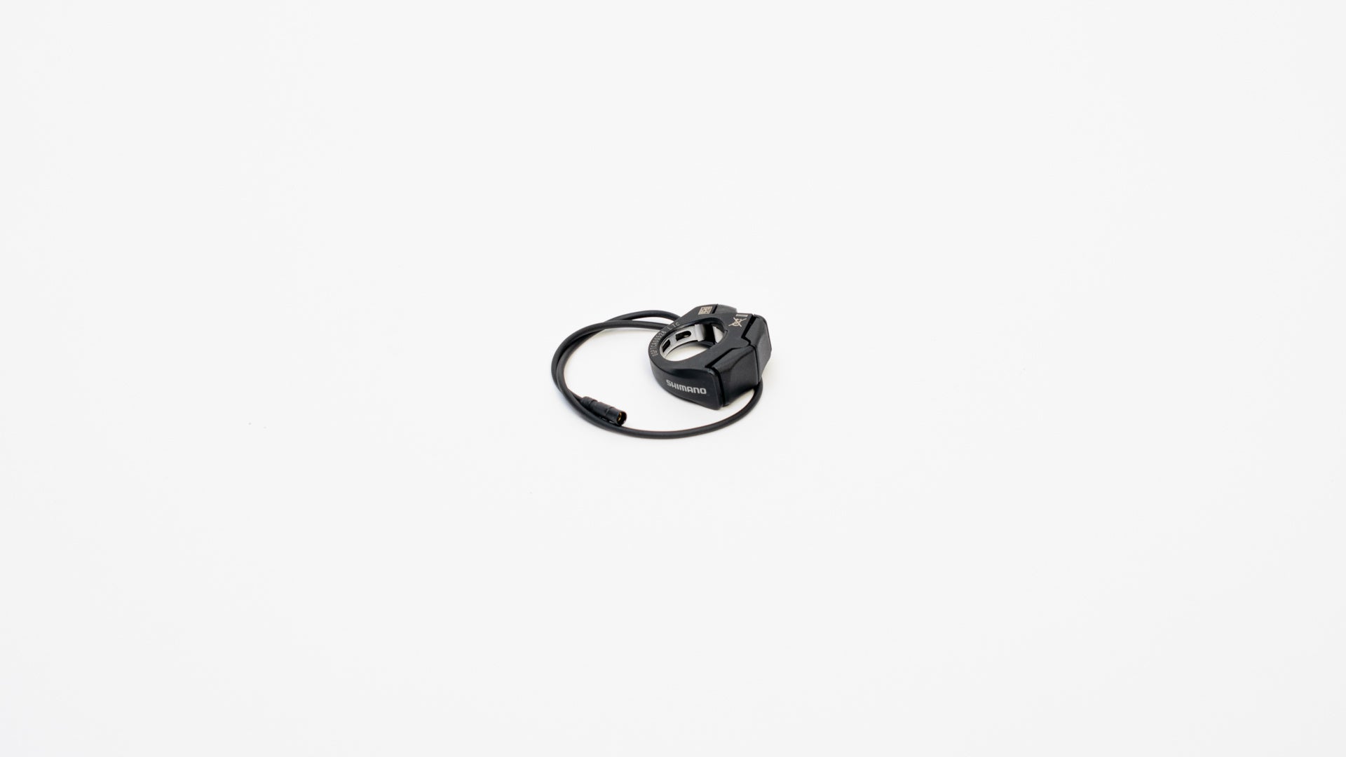 Shimano switch unit with two buttons on white background. The cable for the button is coiled up.